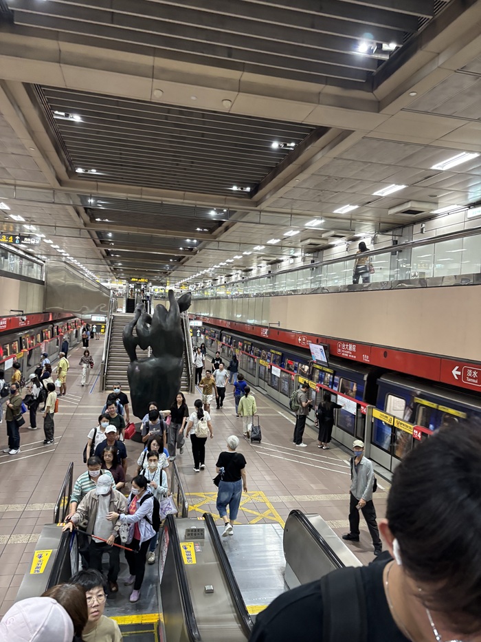 Many people lined up with subway tracks on both sides of the station in Taiwan
