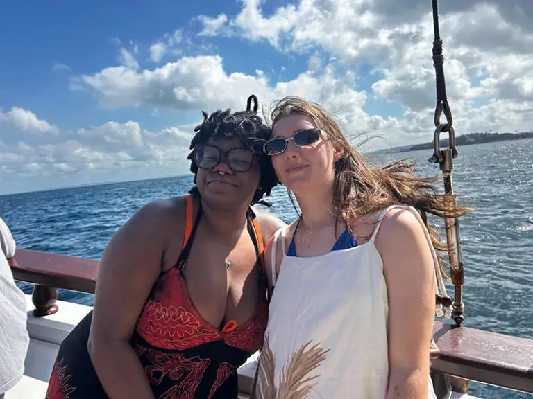 students smiling at camera on the water